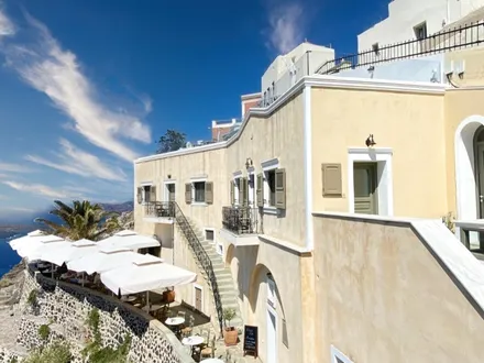 Irini’s Cafe — a cream Cycladic building above the caldera