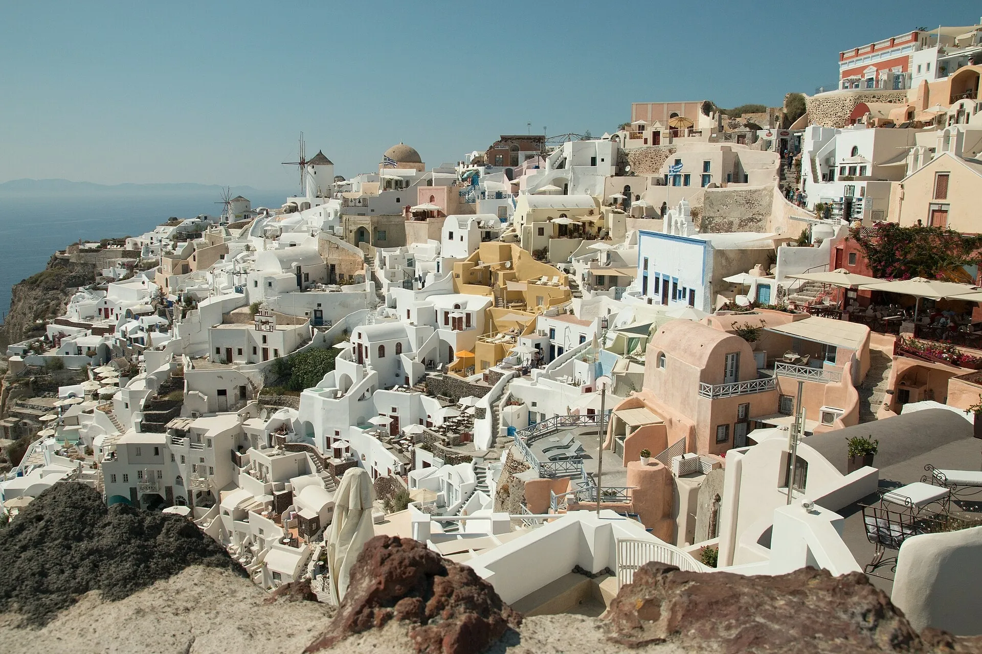 White houses and blue domes stepping down the caldera cliff at Oia, Santorini